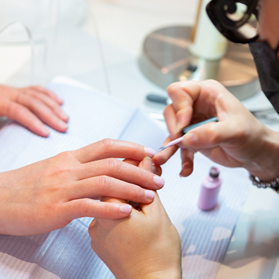 Purlux Esthetician providing manicure service to happy client