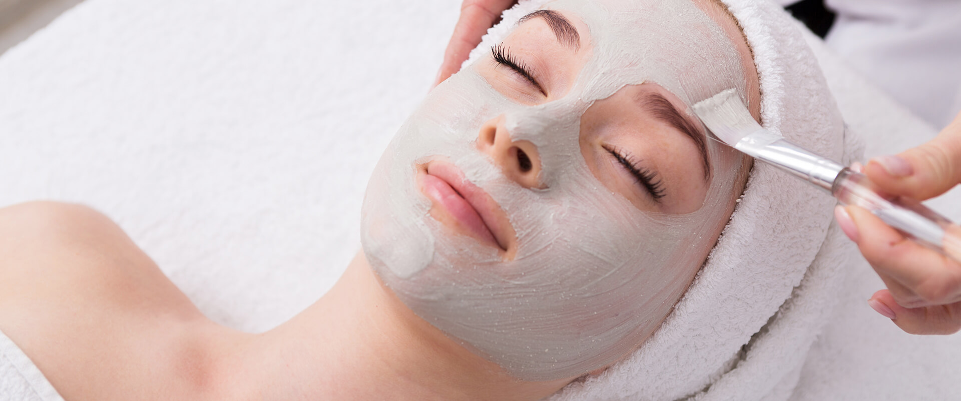 Woman gets face mask by esthetician at Purlux Esthetics & Beauty Salon
