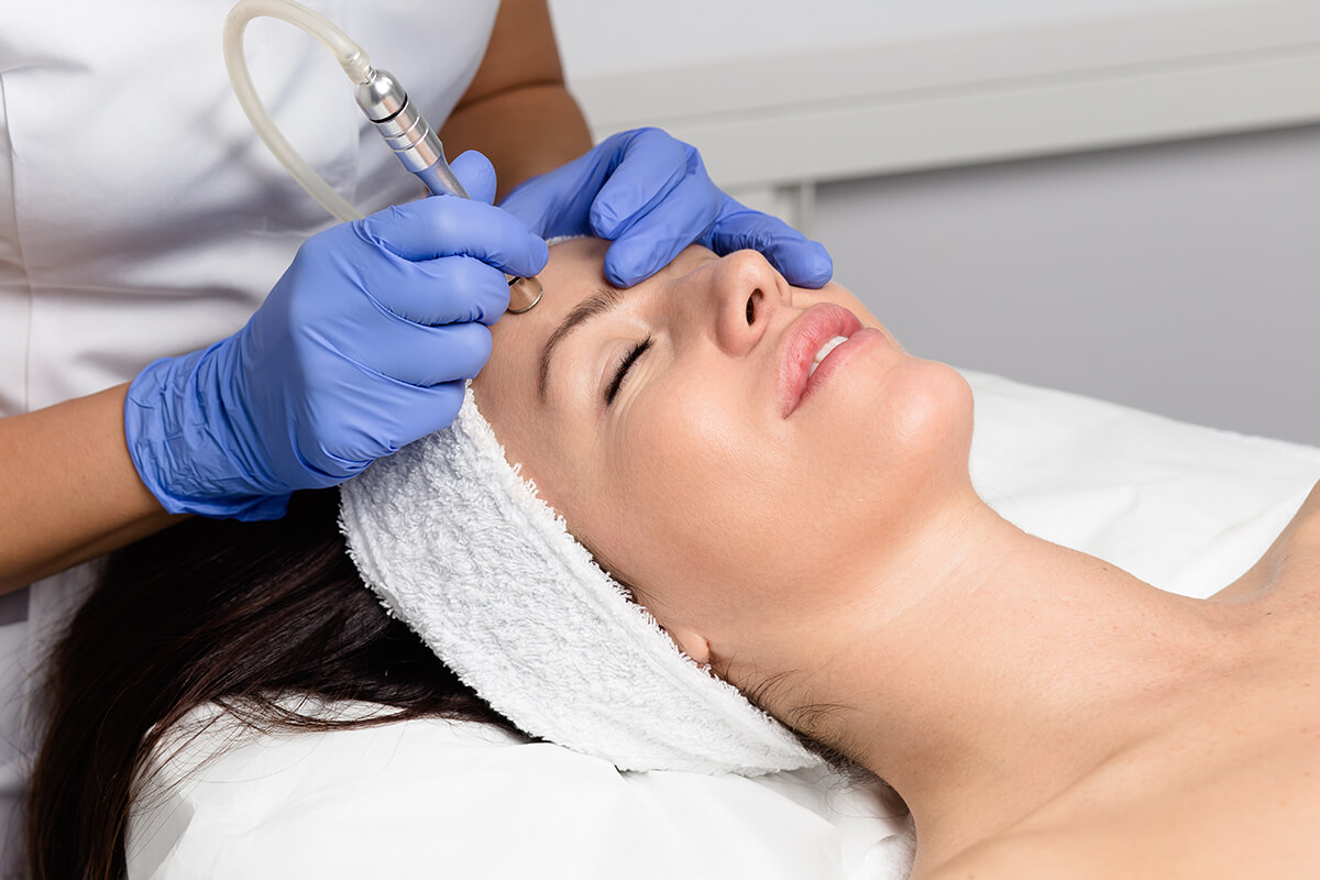 Beautiful woman getting facial microdermabrasion peeling treatment at luxury cosmetic beauty spa clinic. Exfoliation, rejuvenation and hydratation. Cosmetology